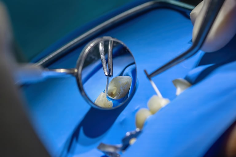 Detailed view of a dentist performing root canal treatment using a rubber dam, mirror, and precision instruments