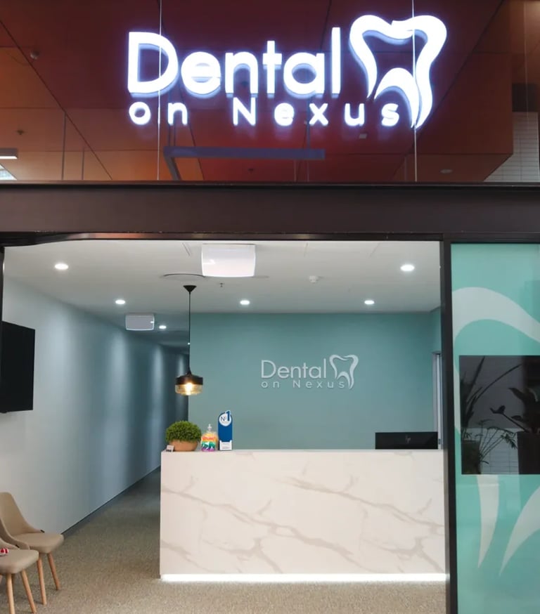 Modern dental clinic storefront with neon Dental on Nexus sign above entrance and turquoise interior reception area with marble desk